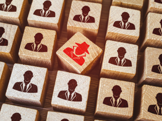 Rows of employee icons with a red imposter employee icon in the midst